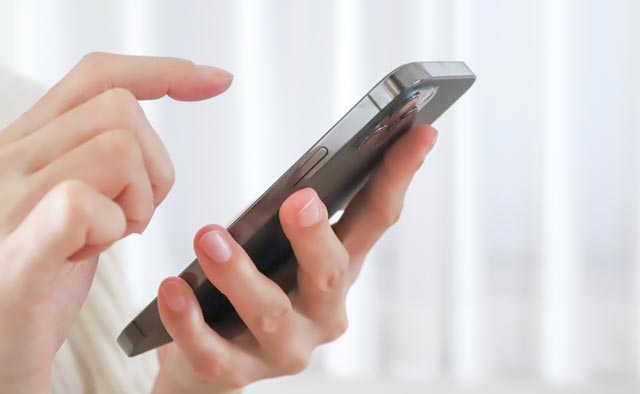 家族葬の〇〇区葬儀社に電話でお問合せしようとしている人の手元。